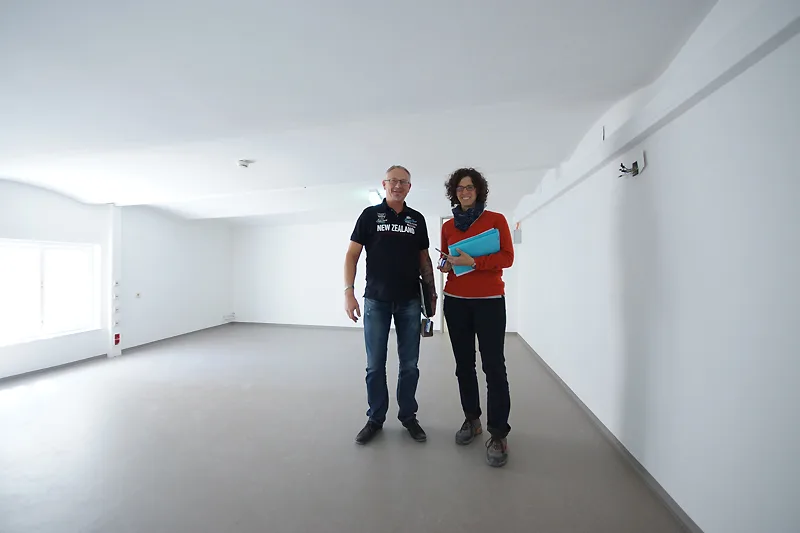 Zwei Personen bei einer Baustellenbesichtigung in einem leeren Raum
