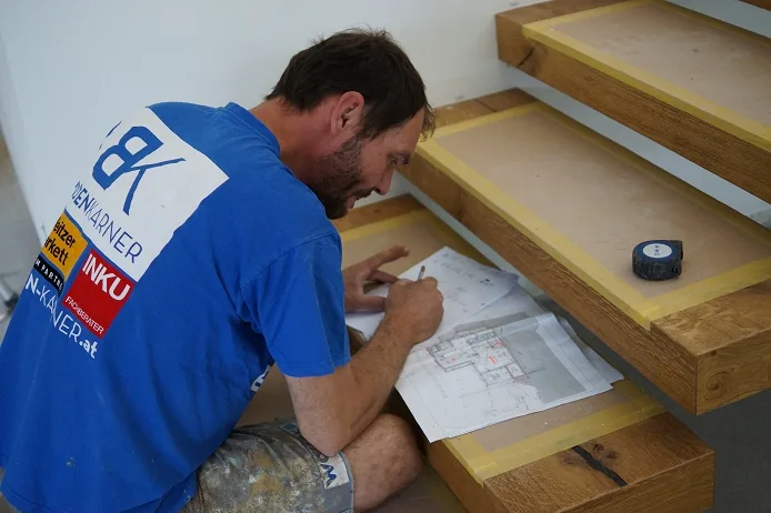 Ein Verleger im Boden-Karner-Shirt arbeitet an einer Stiege